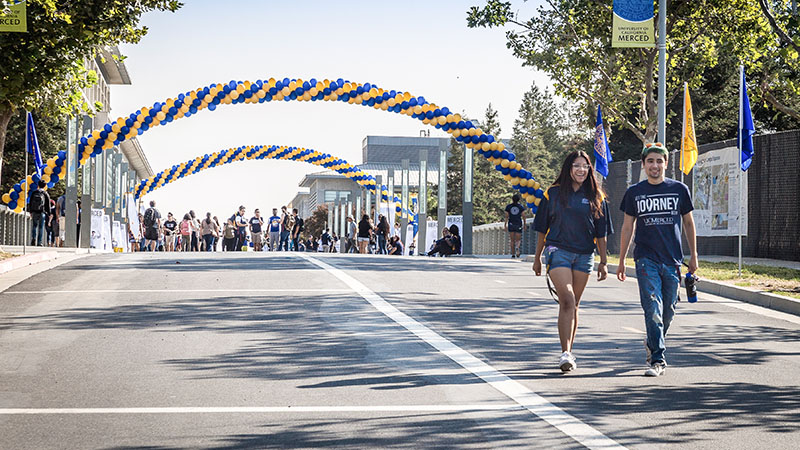students walking across uc merced campus bridge